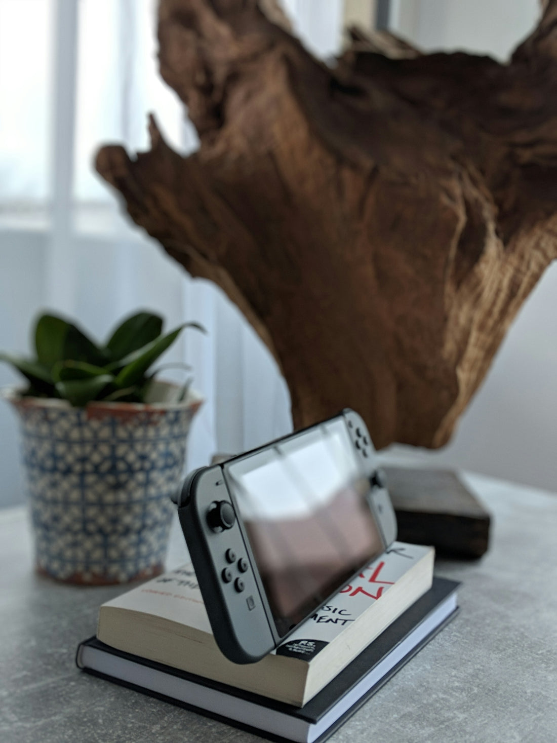 gray Nintendo Switch on top of book