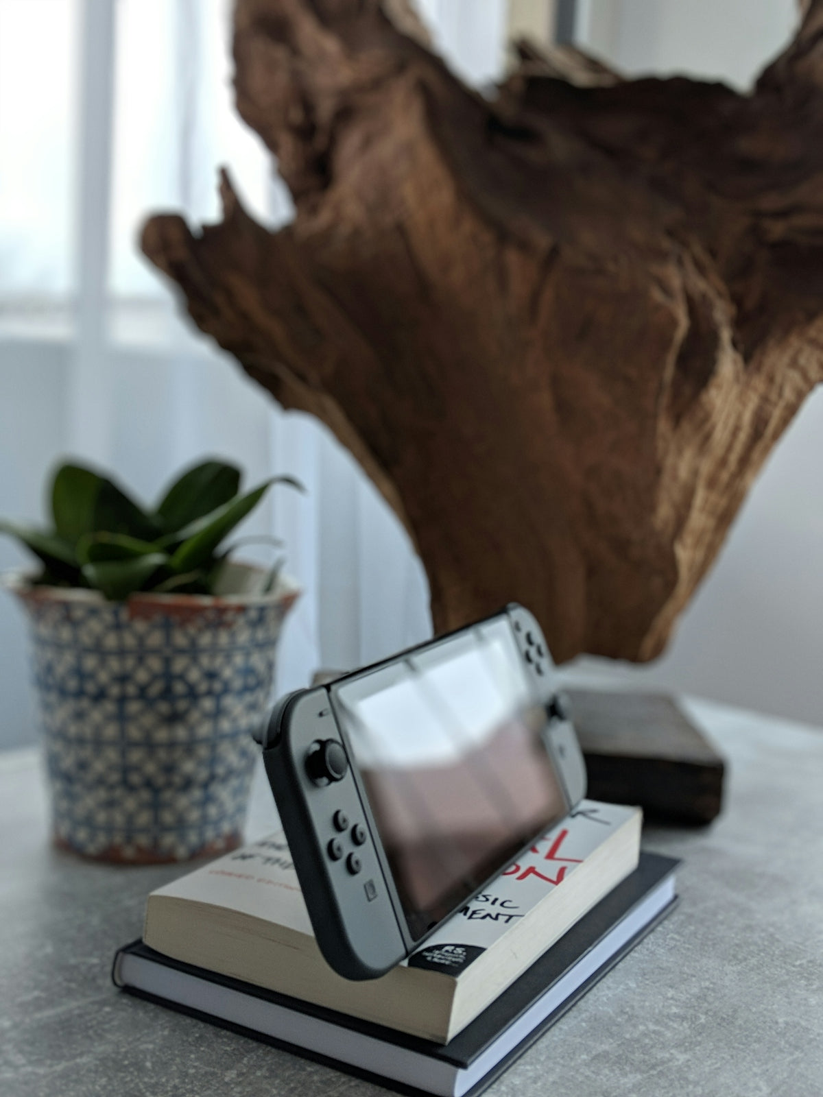 gray Nintendo Switch on top of book