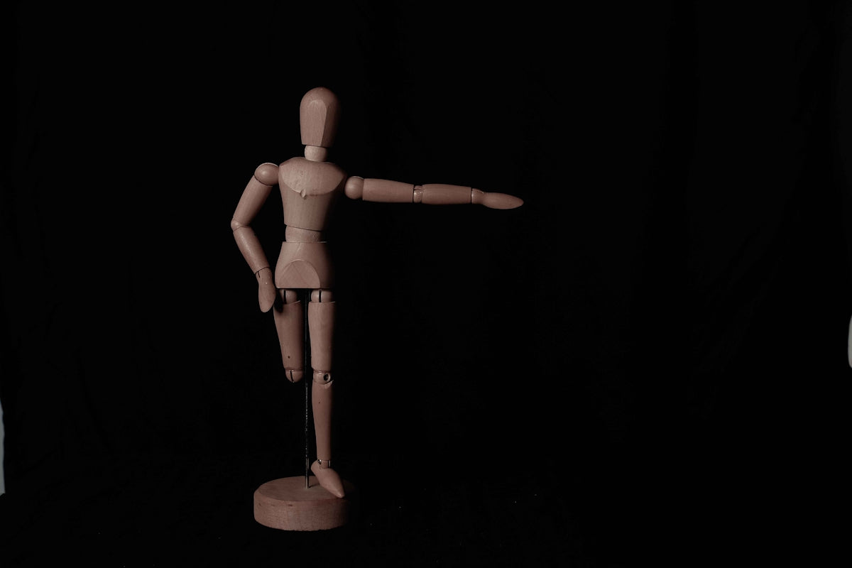 brown wooden human figure on black table