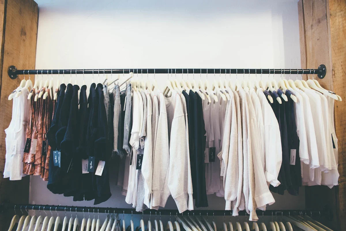 Kläder på galgar i butik, ljusa och mörka tröjor, mode från Nerdbutiken