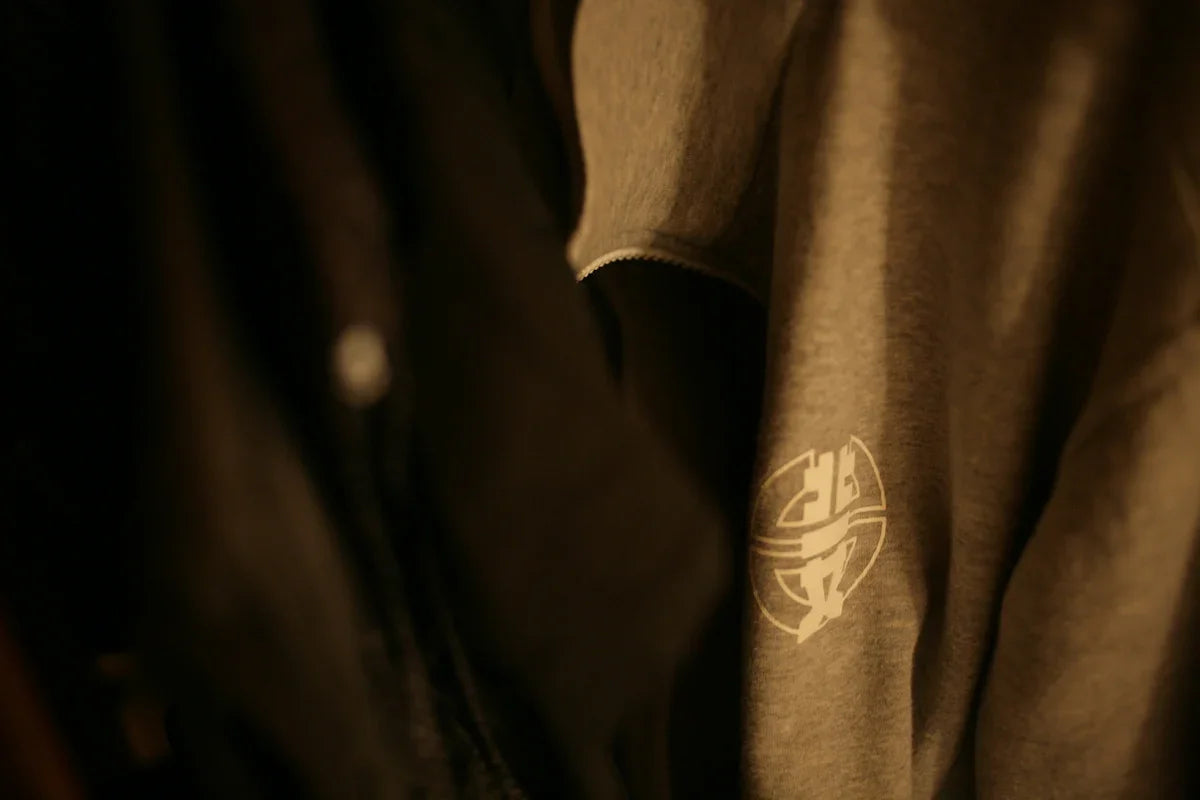 Grå nördig hoodie med vit tryckt logotyp hänger i garderob, Nerdbutiken kläder