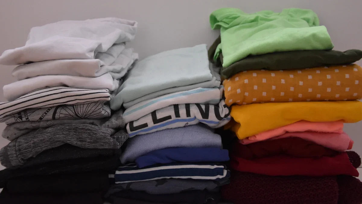Färgglada vikta t-shirts och tröjor staplade i två högar, inspirerat av nördiga kläder från Nerdbutiken.