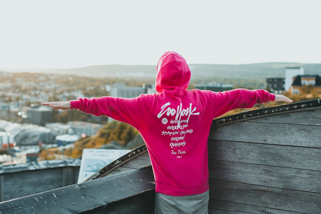 a person in a pink hoodie standing on a roof