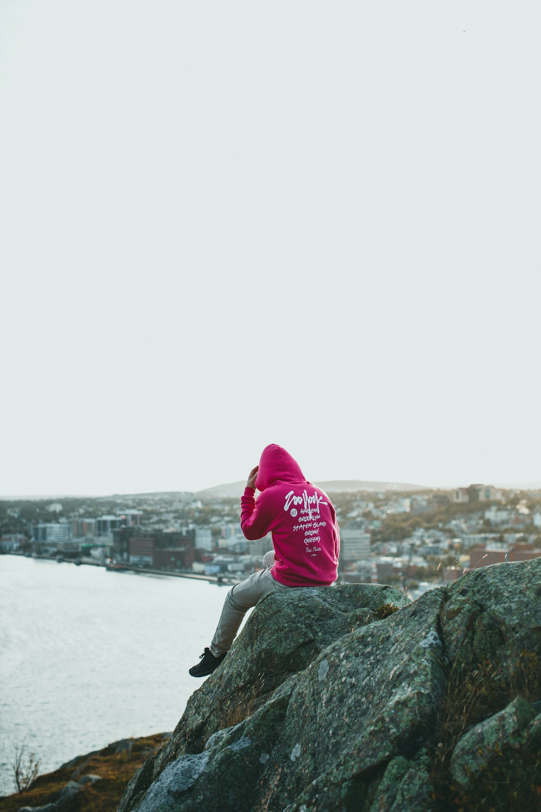 a person sitting on top of a large rock