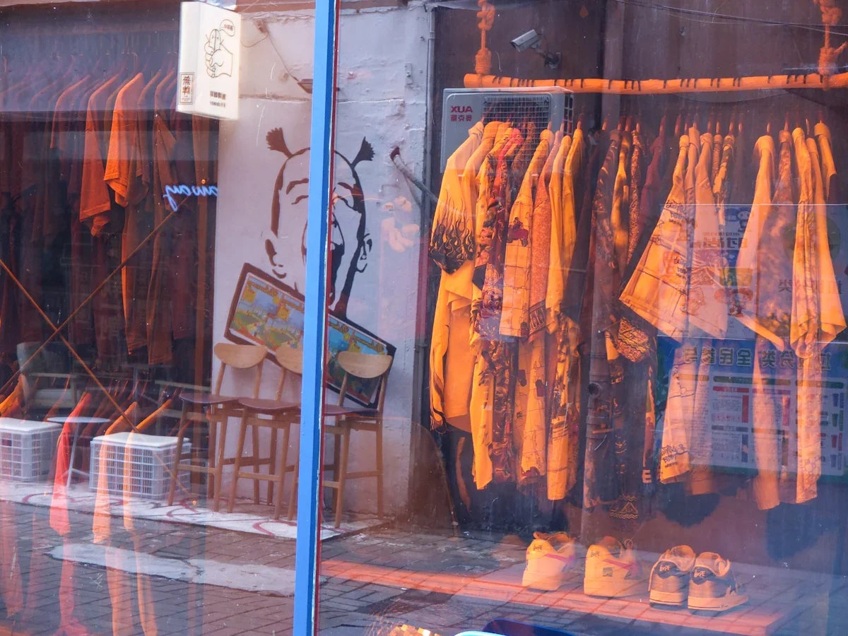 Butiksfönster med färgglada skjortor, sneakers och nördiga inredningsdetaljer i urban stil