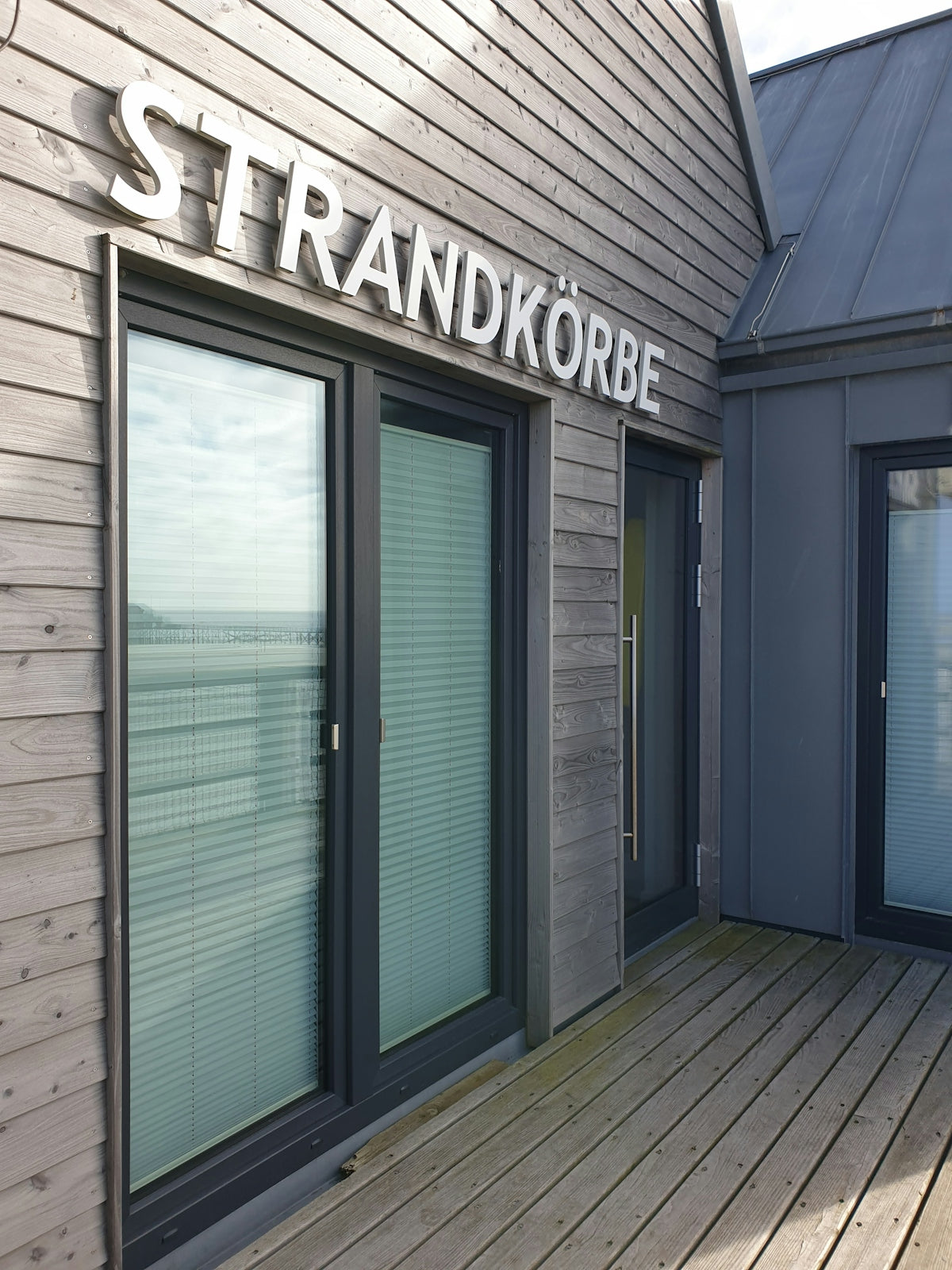 the outside of a building with a wooden deck