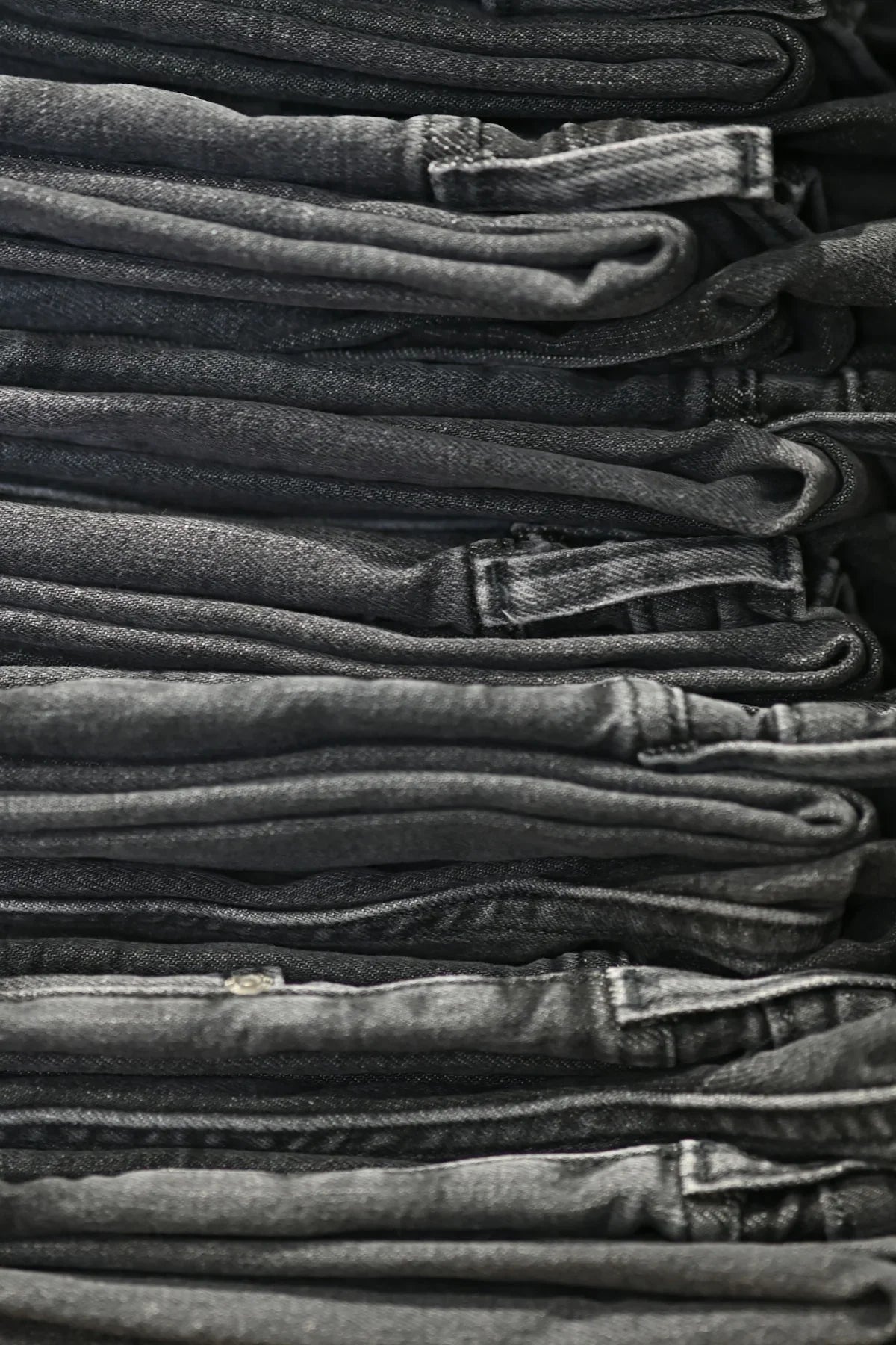 Staplad hög med svarta och gråa jeans hos Nerdbutiken, butik för coola prylar