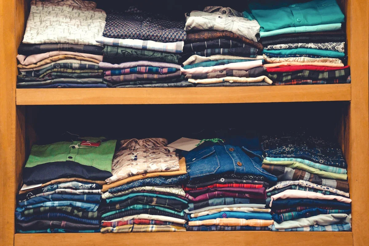 Färggranna vikta skjortor på hyllor i butik, Nerdbutiken, unika mönstrade kläder