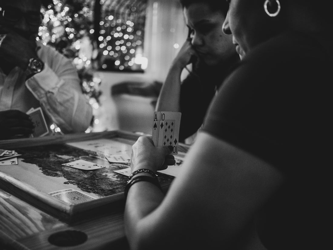 a group of people sitting around a table playing cards