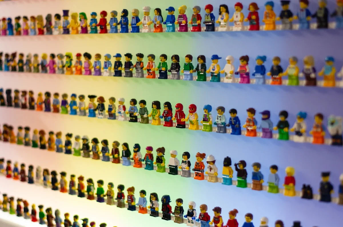 Färgstarka LEGO-minifigurer i rad på hyllor, nördiga samlarprylar hos Nerdbutiken
