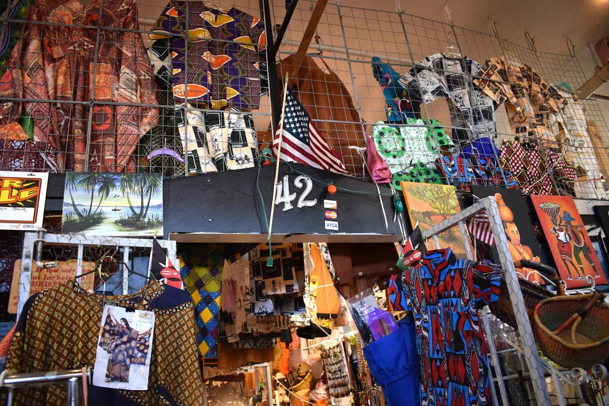Färgglada afrikanska kläder och konstverk i en butik, nummer 42, kulturella dekorationer