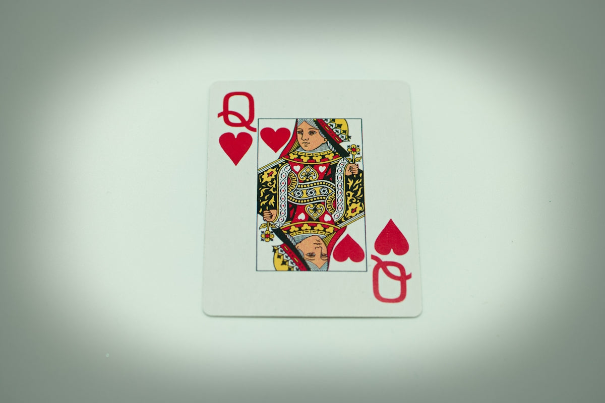 a playing card with a queen of hearts on it