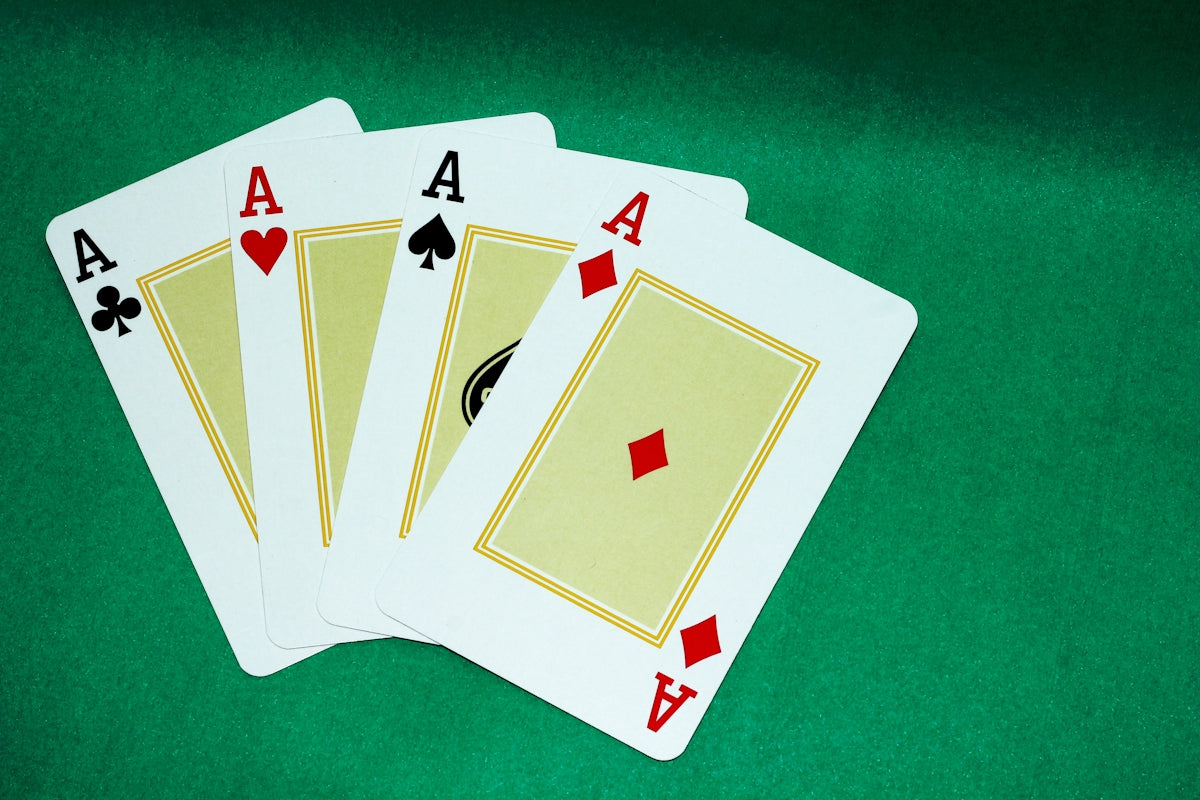 Four of a kind of playing cards on a green table