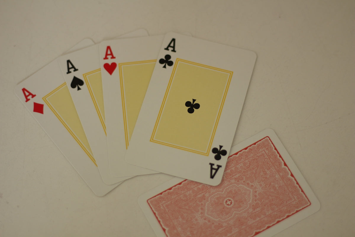 Four of a kind of playing cards sitting on top of a table