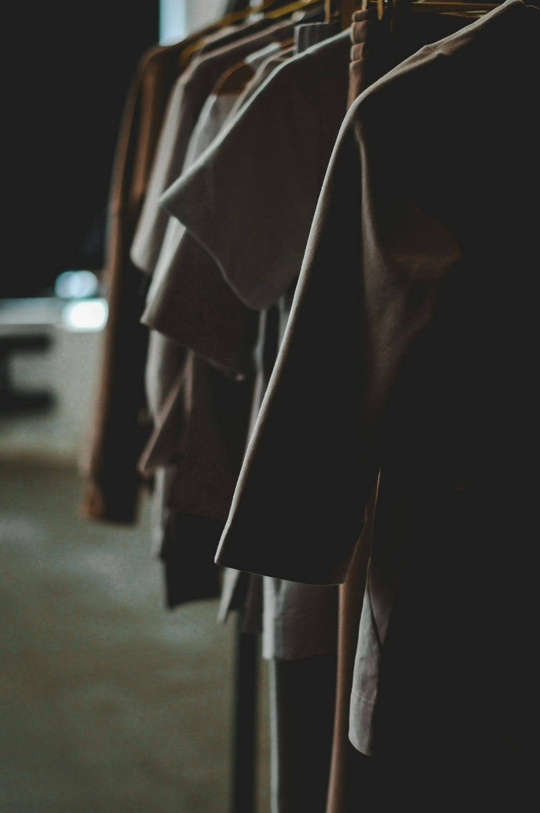 Clothes hang neatly on a rack in a store.