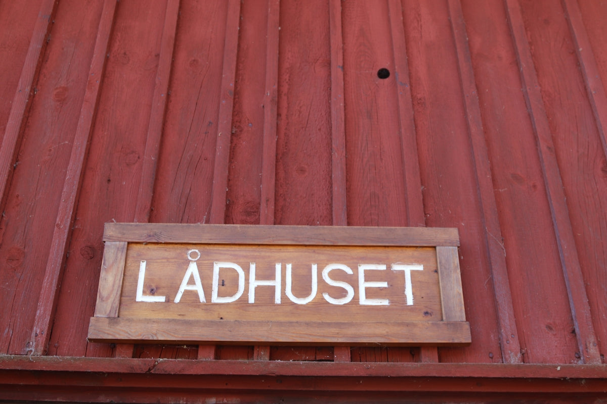A wooden sign with lådhuset is shown.