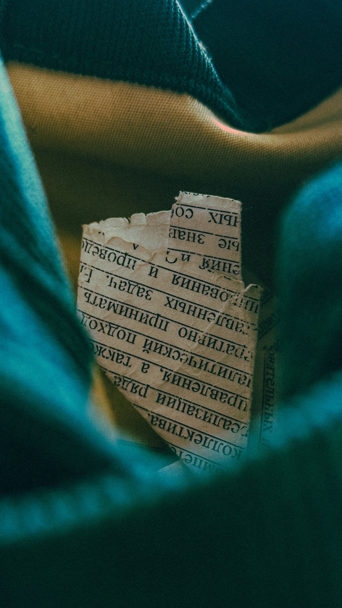 Torn piece of paper with text inside fabric