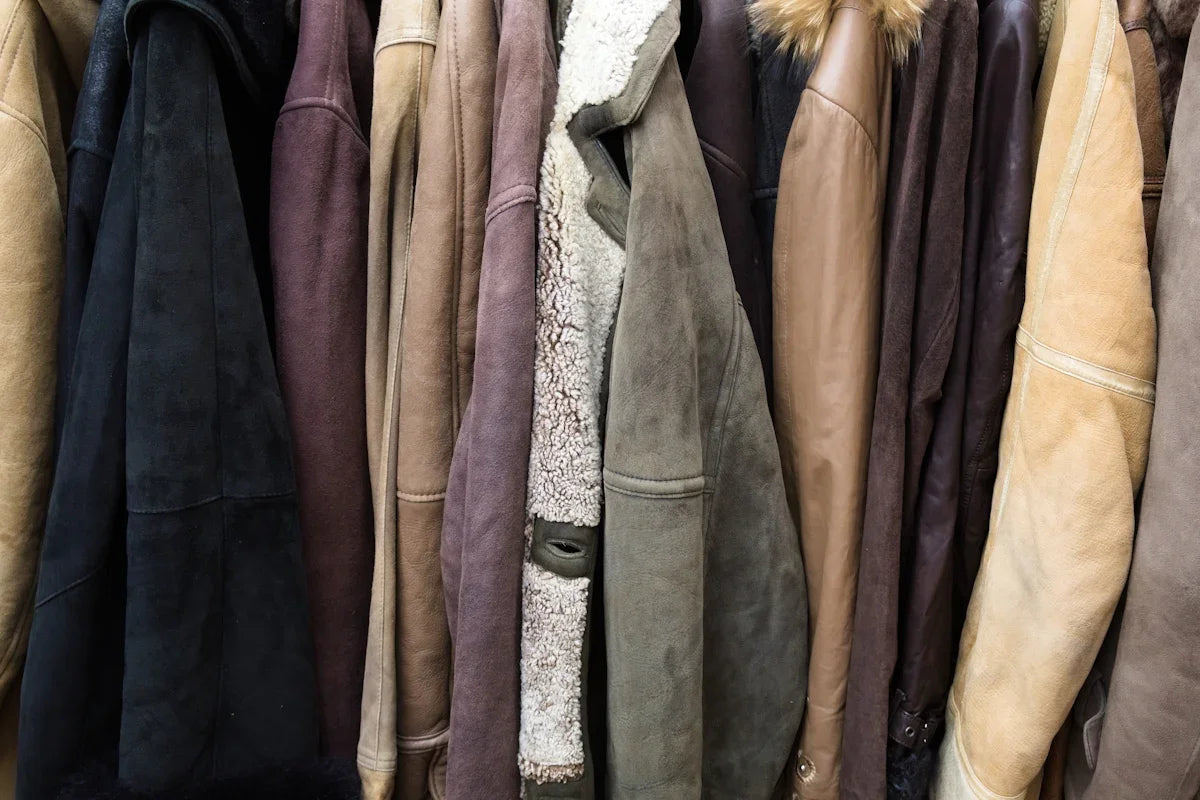 Flera vintage mockajackor och läderjackor i olika färger hänger på rad, Nerdbutiken.