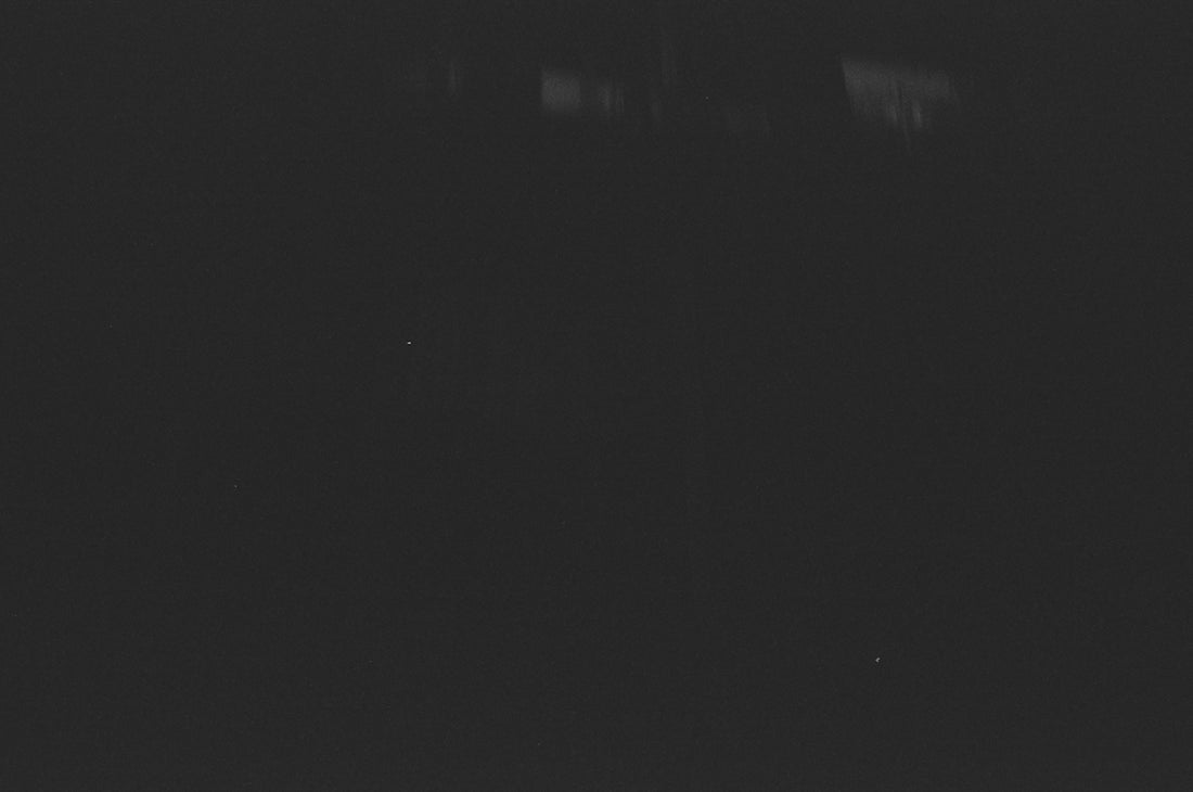 A dark, grainy background with faint lights