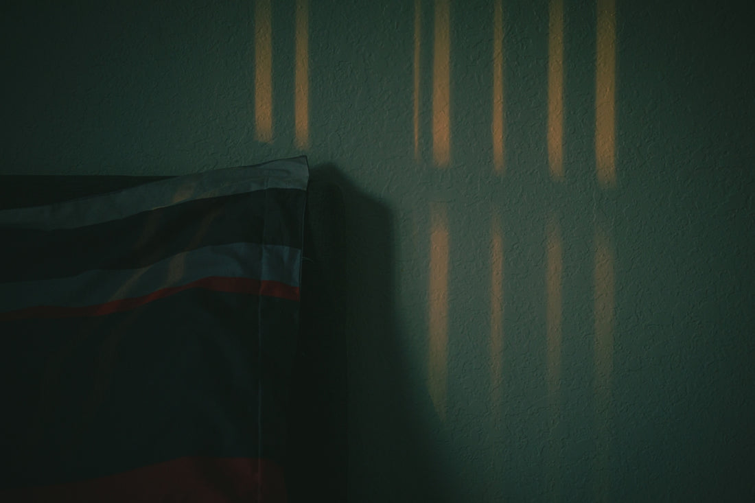 Sunlight stripes on a dark wall.